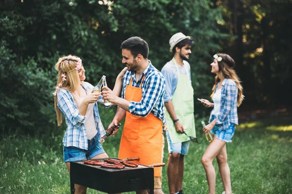 Amici trascorrere del tempo nella natura e fare barbecue — Foto Stock