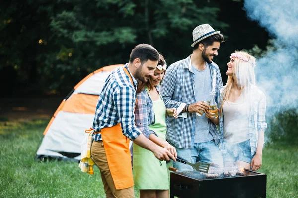 Amigos gastando tempo na natureza e fazendo churrasco — Fotografia de Stock