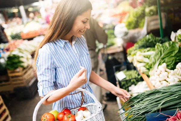 Фото женщины на рынке, покупающей овощи — стоковое фото