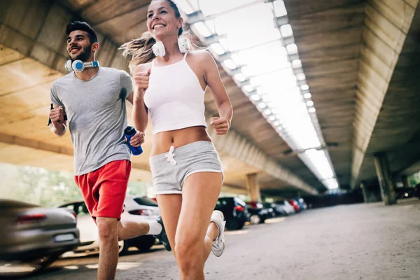 Hombre atractivo y mujer hermosa trotando juntos — Foto de Stock