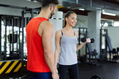 Spor salonunda antrenör ile çalışma dışarı genç yetişkin kadın