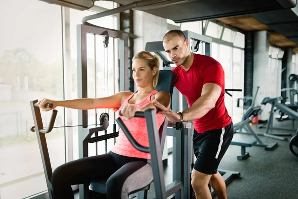 Beautiful girl working out with personal trainer — Stock Photo, Image
