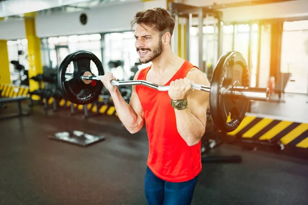 Gespierde bodybuilder training in de sportschool doen biceps oefeningen — Stockfoto