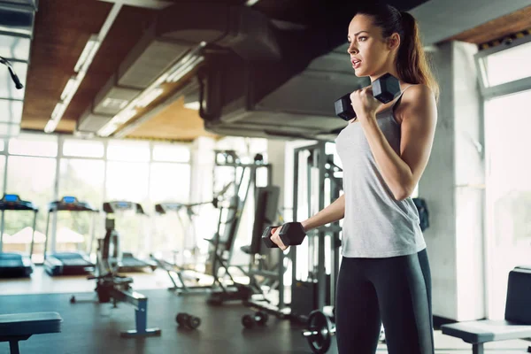 Mooie jonge vrouw doen oefeningen voor de biceps — Stockfoto