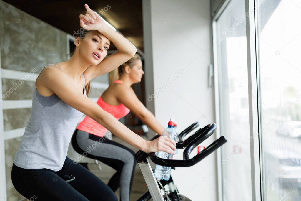 Beautiful woman riding sport bike in gym
