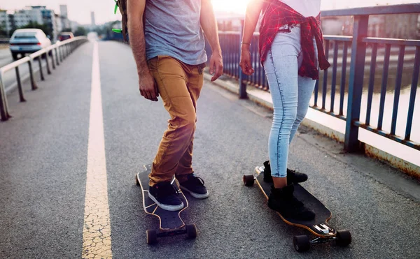 Jovem casal atraente andar de skate e se divertindo — Fotografia de Stock