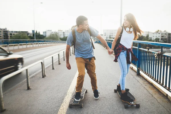 Νεαρό ζευγάρι ελκυστική ιππασία skateboards και τη διασκέδαση — Φωτογραφία Αρχείου