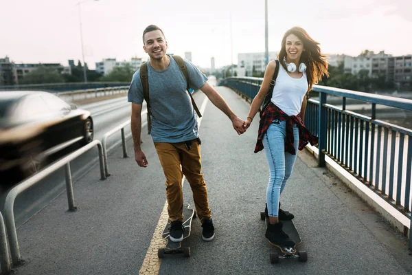 Mladý atraktivní pár na koni skateboardy a baví — Stock fotografie