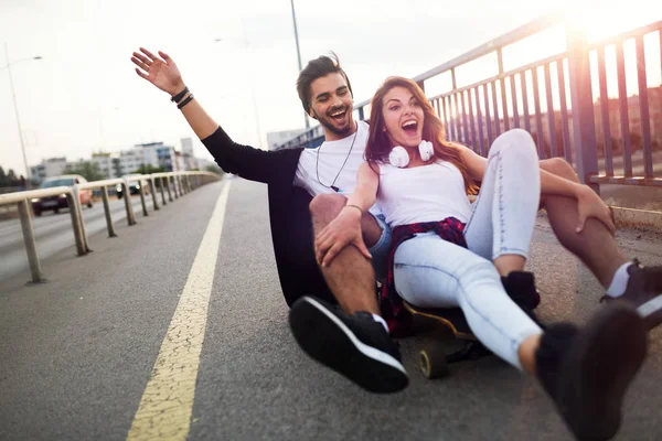 Giovane coppia attraente equitazione skateboard e divertirsi — Foto Stock