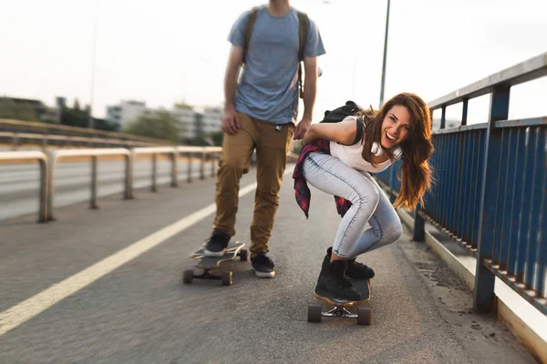 Jovem casal atraente andar de skate e se divertindo — Fotografia de Stock