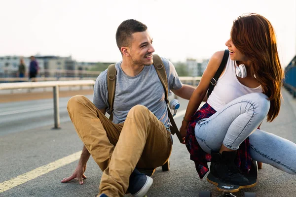 Jovem casal atraente andar de skate e se divertindo — Fotografia de Stock