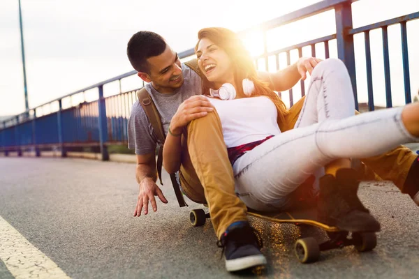 Joven pareja atractiva montar monopatines y divertirse —  Fotos de Stock