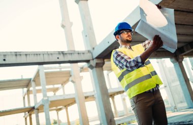 Planı inceleyen inşaat mühendisinin resmi