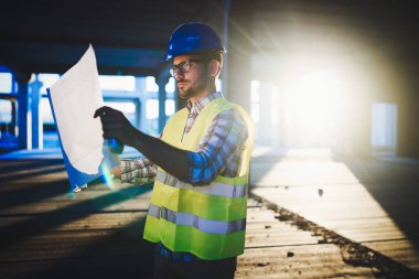 Planı inceleyen inşaat mühendisinin resmi