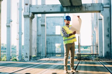 Planı inceleyen inşaat mühendisinin resmi