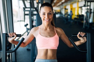 Genç çekici kadın spor salonunda egzersizleri yapıyor