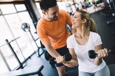 Güzel kadının kişisel antrenör ile spor salonunda egzersiz yapması