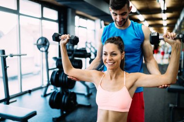 Güzel kadının kişisel antrenör ile spor salonunda egzersiz yapması