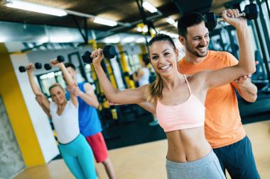 Güzel kadınlar içinde jimnastik salonu ile kişisel eğitmenler egzersizleri yapıyor