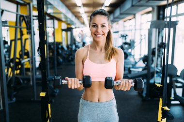 Genç çekici kadın spor salonunda egzersizleri yapıyor