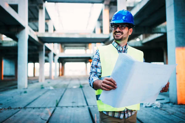 Picture of construction site engineer looking at plan — Stock Photo, Image