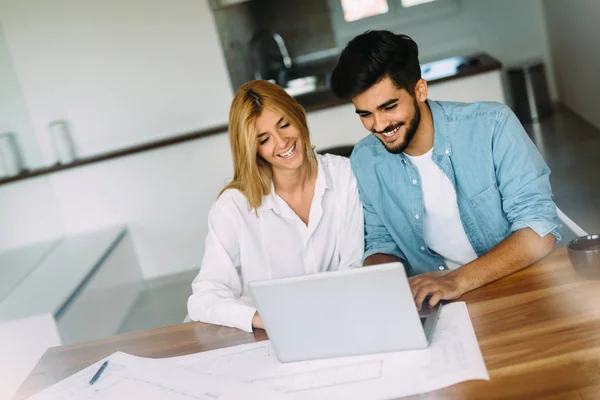 Pohledný mladý muž a atraktivní žena pracující na laptop — Stock fotografie