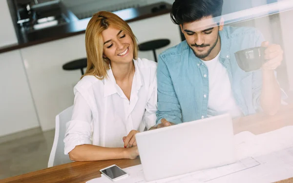 Bello giovane uomo e donna attraente che lavora sul computer portatile — Foto Stock