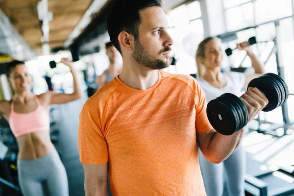 Grupo de amigos haciendo ejercicio juntos en el gimnasio — Foto de Stock