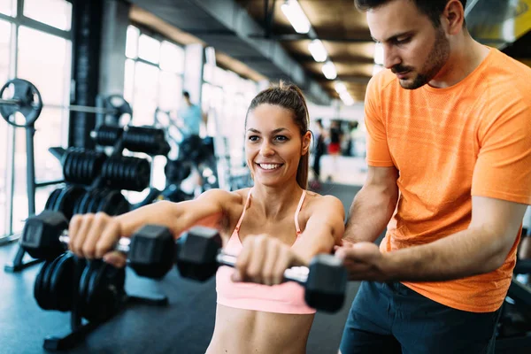 Wanita cantik melakukan latihan di gym dengan pelatih pribadi — Stok Foto