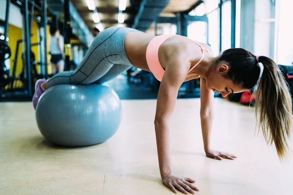 Fitness vrouw werken push-ups in sportschool — Stockfoto