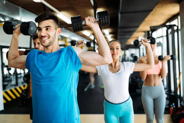 Grupo de amigos haciendo ejercicio juntos en el gimnasio — Foto de Stock