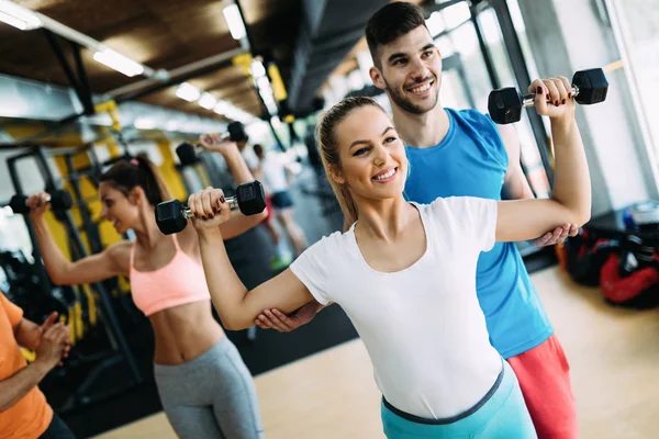 Schöne Frau macht Übungen im Fitnessstudio mit Personal Trainer — Stockfoto