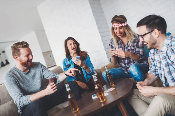 Šťastné skupina přátel, hrací karty a pití — Stock fotografie