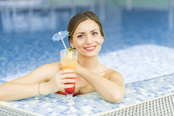 Hermosa mujer en una piscina con un cóctel —  Fotos de Stock