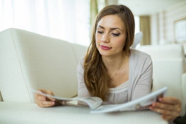 Bir kanepe oturma odasında okumamı güzel kadın