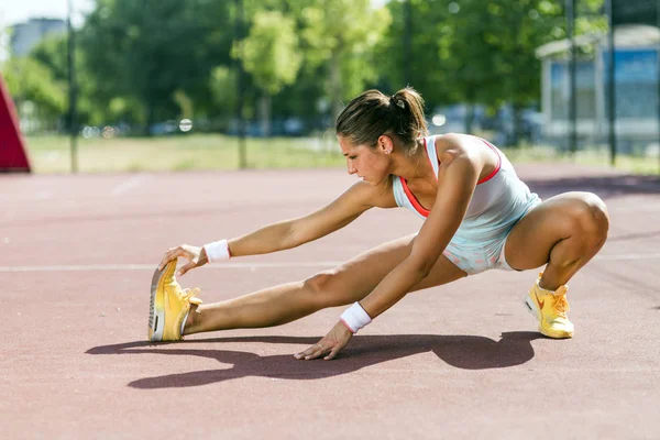 Schöne junge athletische Frau dehnt sich im Sommer — Stockfoto