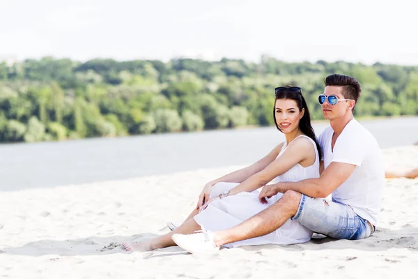 年轻夫妇坐在海滩 — 图库照片