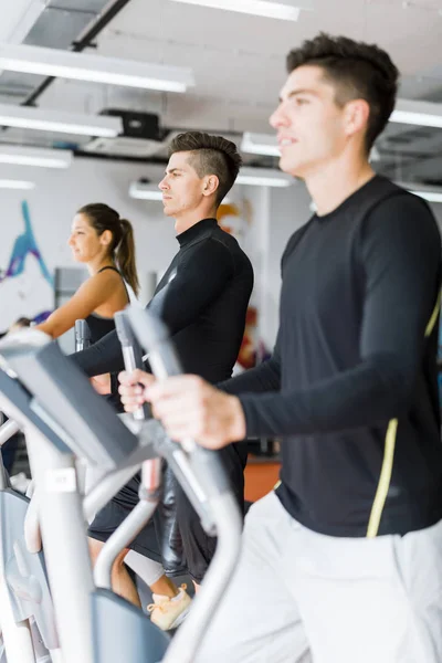 Gente entrenando en un entrenador elíptico — Foto de Stock