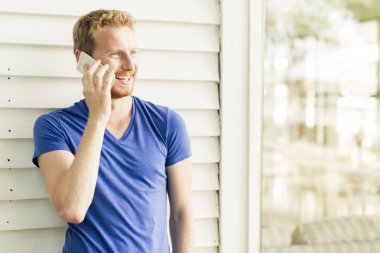 telefon kullanarak ve gülümseyen yakışıklı adam