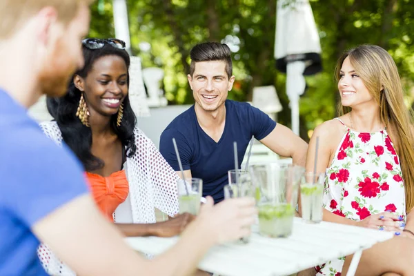 Happy vrienden praten aan een tafel — Stockfoto