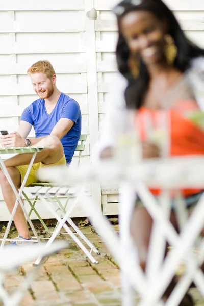 Happy man holding phone in a cafe — Stock Photo, Image