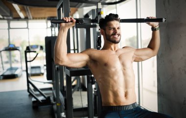 Makine üzerinde spor salonunda eğitim genç vücut geliştirmeci