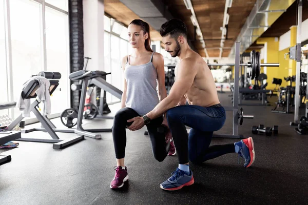 Jovem mulher atraente fazendo exercícios no ginásio — Fotografia de Stock