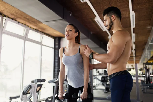 Jovem mulher atraente fazendo exercícios no ginásio — Fotografia de Stock