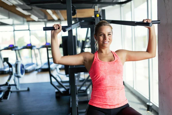 Vacker ung kvinna som gör övningar i gymmet — Stockfoto