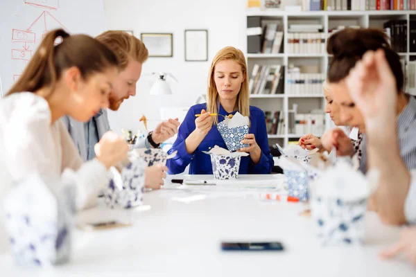 Empresários comendo no escritório — Fotografia de Stock