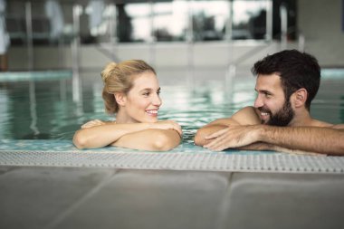 Mutlu çift rahatlatıcı yüzme havuzunda
