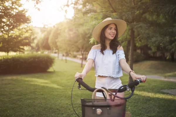 Retrato de bela jovem aproveitando o tempo na bicicleta — Fotografia de Stock