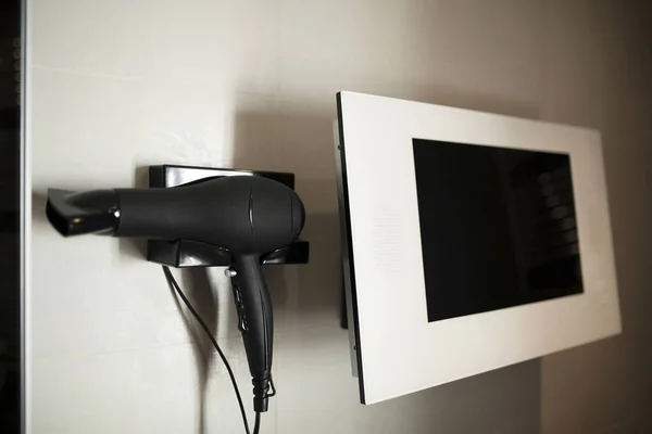 Gambar pengering rambut hitam dan monitor putih — Stok Foto