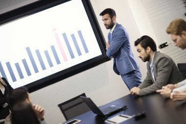 Genç ve çekici iş adamı meslektaşlarına sunum yapıyor.